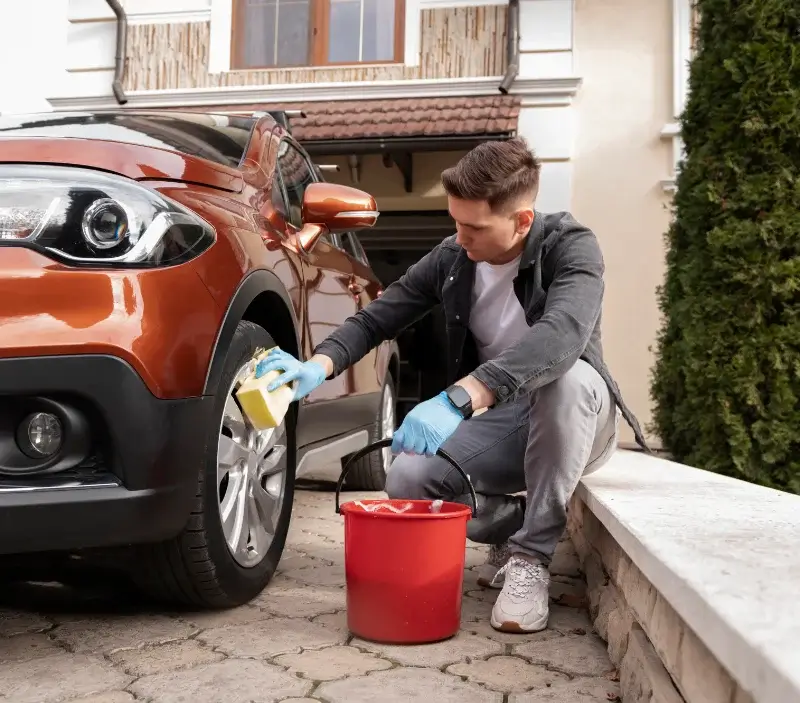 Lavage auto à domicile Champagne-sur-Oise : professionnel intervenant sur un véhicule